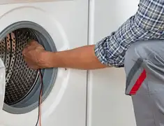 Dryer repair technician diagnosing and servicing a clothes dryer in Manchester, NH