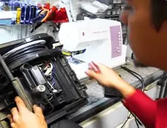 Vacuum repair technician servicing internal components on a workbench in Manchester, NH