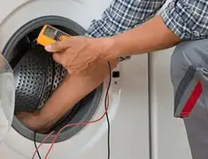 Washing machine repair technician testing a front-load washer with diagnostic tools in Manchester, NH