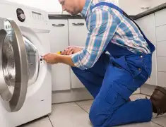 Washing machine repair technician servicing a front-load washer in Manchester, NH